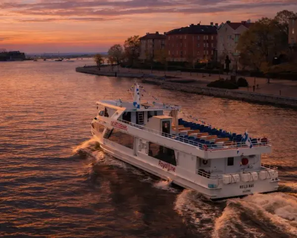 Prom Royal Line "Helsinki" płynie po wodzie podczas zachodu słońca, tworząc fale.