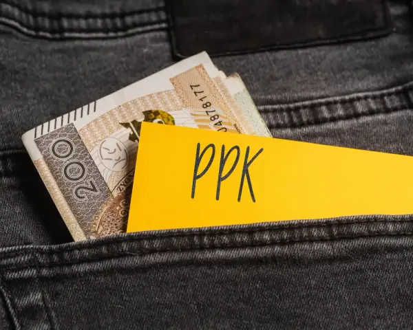 Karta z napisem "ppk" i banknoty w tylnej kieszeni dżinsów. Decyzja o rezygnacji z PPK.