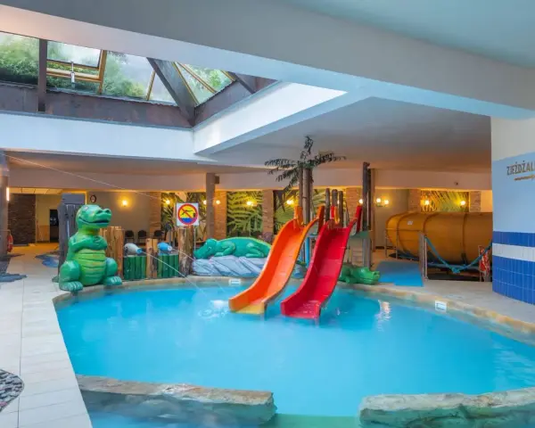 Karpacz hotel z basenem i atrakcjami dla dzieci: zjeżdżalnie, basen, zielone dinozaury i tropikalne dekoracje.