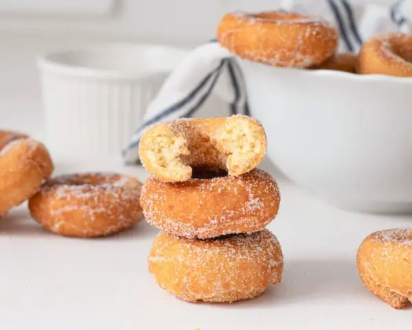 Rosquillas caseras de toda la vida, doradas y espolvoreadas con azúcar. Un bocado dulce que evoca recuerdos.