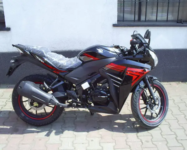 Czarny motocykl Zipp Xrace 50 z czerwonymi akcentami, gotowy do jazdy po miejskich ulicach.