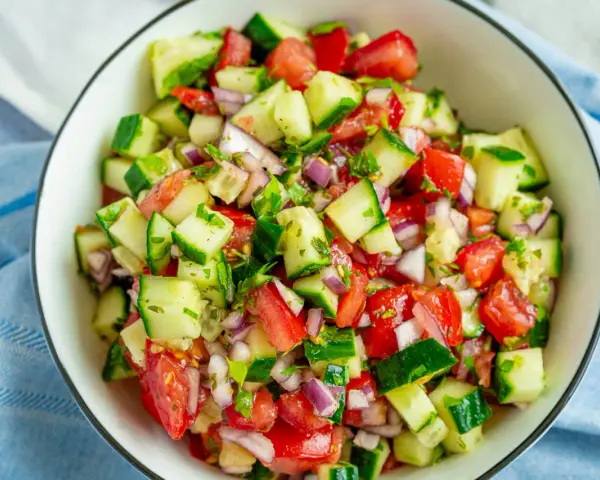 Frischer Sommersalat mit Tomaten, Gurken und roten Zwiebeln – ein einfaches und leckeres Rezept für heiße Tage.