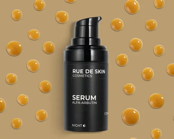 Czarny flakonik serum z alfa-arbutyną, otoczony kropelkami o bursztynowym kolorze.