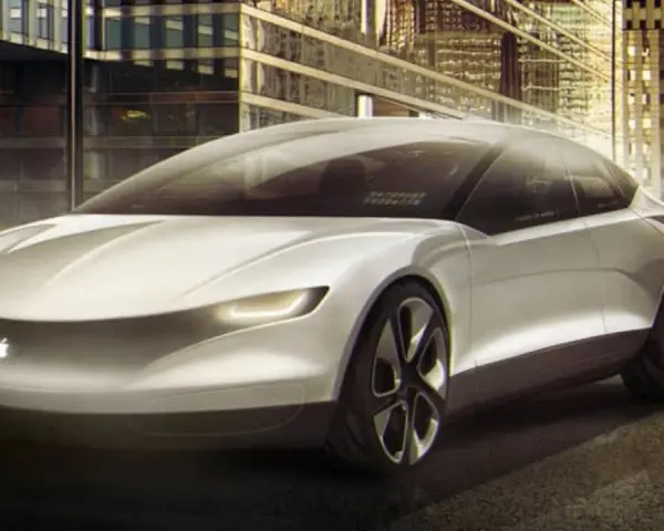 Futurystyczny, biały apple car z podświetlanym logo jabłka, zaparkowany przed nowoczesnymi budynkami w nocy.