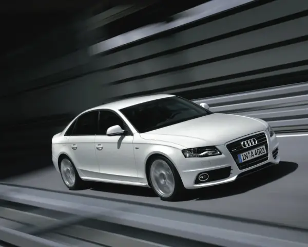 Białe Audi A4 B8 w ruchu, z rozmytym tłem. Wiele osób szuka audi a4 b8 opinie, by poznać jego zalety.