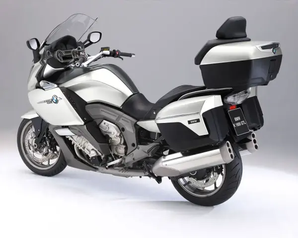 Srebrny motocykl BMW K1600GTL z kuframi i podnóżkami. Idealny do długich podróży, sprawdź jego bmw k1600gtl dane techniczne.