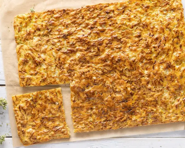 Una dorata schiacciata di zucchine, croccante fuori e morbida dentro, pronta per essere gustata.
