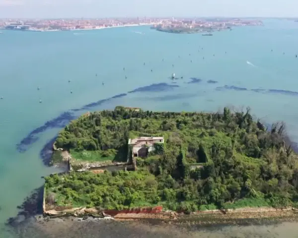 Un'isola verdeggiante con ruderi antichi, circondata da acque azzurre. Venezia è un'isola, e questa vista aerea ne mostra la bellezza selvaggia.