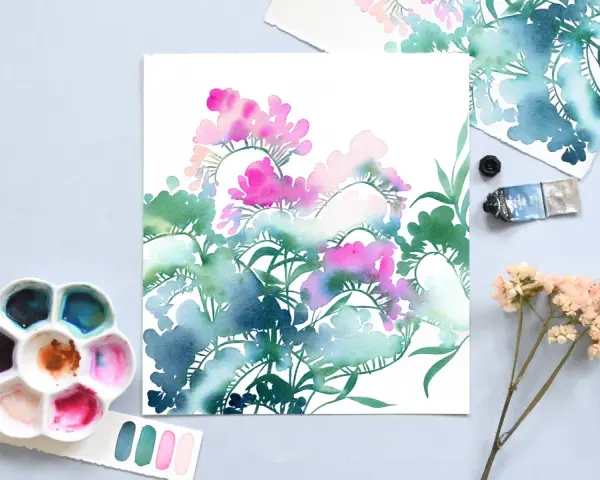 Palette d'aquarelle et tube de peinture prêts à peindre fleur. Des touches de rose et de bleu sur papier blanc.