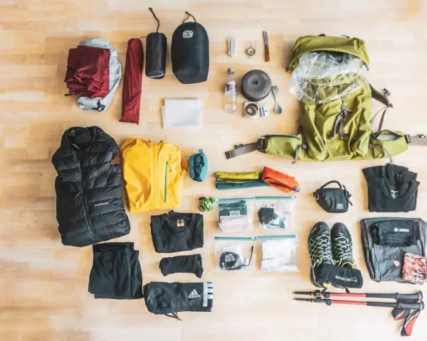Rucksack, Zelt, Schlafsack, Jacken, Schuhe, Wanderstöcke und weitere Ausrüstung für eine perfekte backpacking packliste.