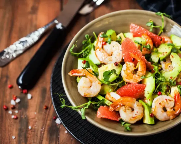 Salade avocat crevette fraîche et colorée, garnie de pamplemousse et de pousses vertes. Un délice léger.