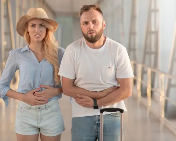 Para podróżnych z walizkami cierpi na biegunkę. Potrzebne tabletki na biegunke.