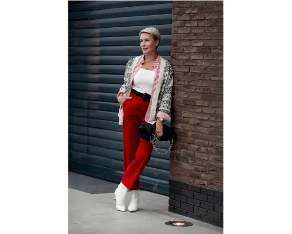Elegancka kobieta w czerwonych spodniach i wzorzystej marynarce, prezentująca modne stylizacje.