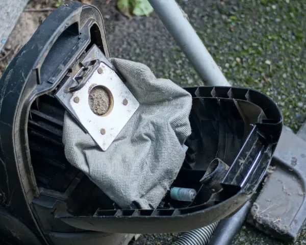 Ein staubsauger beutel wechseln ist nötig. Der alte, volle Beutel liegt offen, bereit für den Austausch.