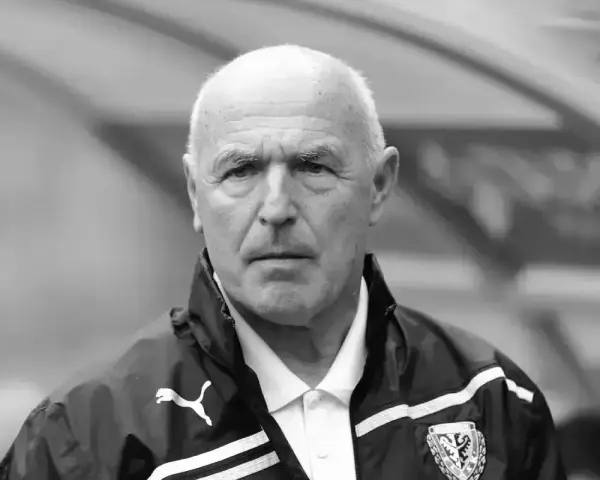 Portret siwowłosego mężczyzny, lenczyk trener piłkarski, w kurtce sportowej z logo Puma.