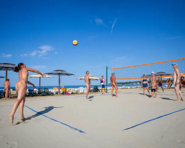 Gra w siatkówkę na plaży w Valalta naturist camp. Słońce, piasek i sportowa rywalizacja w wolności.