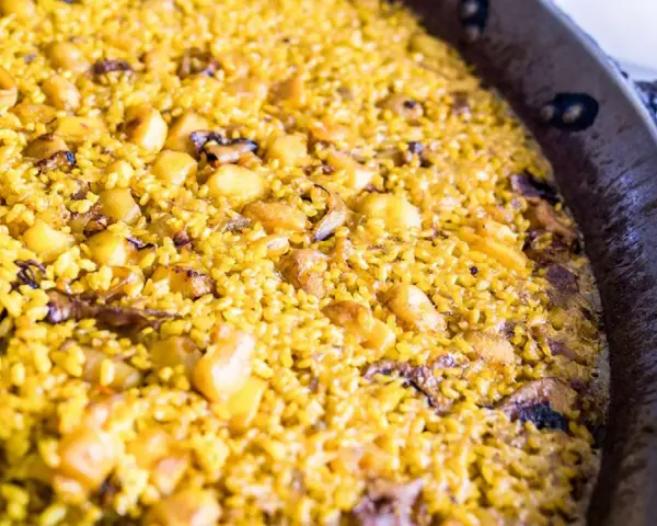 Arroz a banda recién hecho, con trozos de patata y marisco, listo para disfrutar.