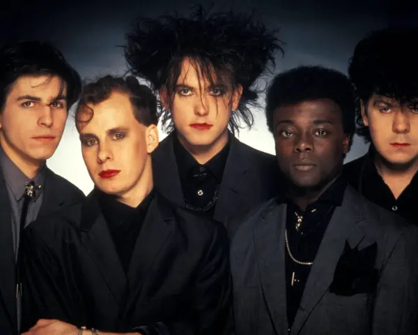 The Cure, zespół legendarnych muzyków, prezentuje swoje ikoniczne utwory w mrocznym stylu.