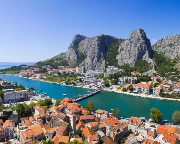 Widok na miasto Omiš w Chorwacji, gdzie rzeka Cetina wpada do morza. Piękne, turkusowe morze i góry.