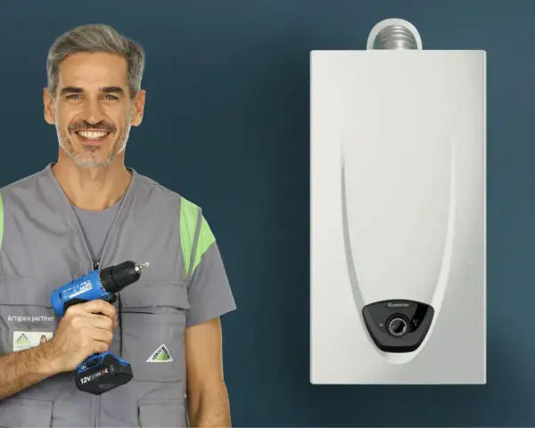Installazione scaldabagno a gas normativa: un artigiano sorridente con trapano pronto per il lavoro, accanto a un nuovo scaldabagno.