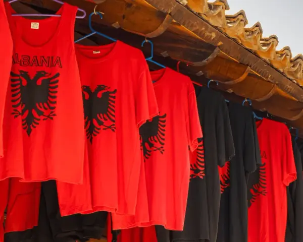 Czerwone i czarne koszulki z dwugłowym orłem, idealne pamiątki, co można przywieźć z Albanii samolotem.