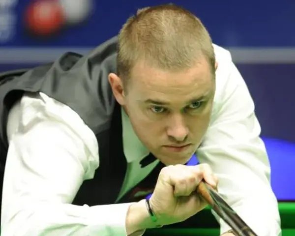 Gracz snookera w skupieniu celuje kijem do bili. Czy to on zostanie mistrzem świata w snookerze 2025?