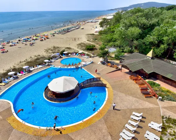 Słoneczny dzień w Albena Bułgaria. Ludzie odpoczywają na plaży i kąpią się w basenie z barem.