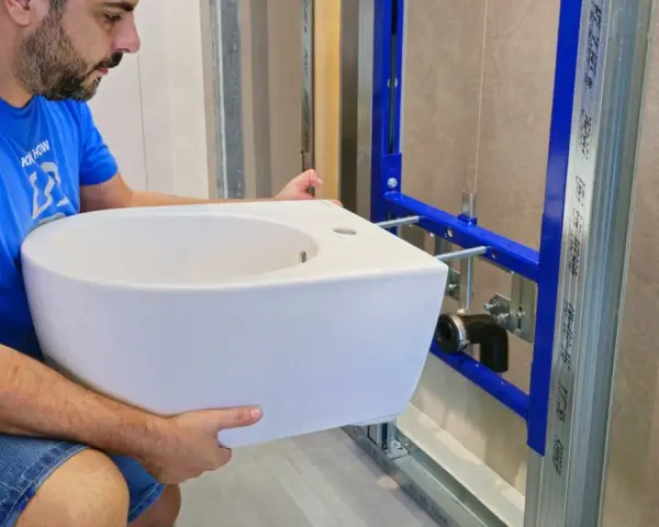 Un homme installe un bidet blanc, un élément essentiel pour une hygiène intime.