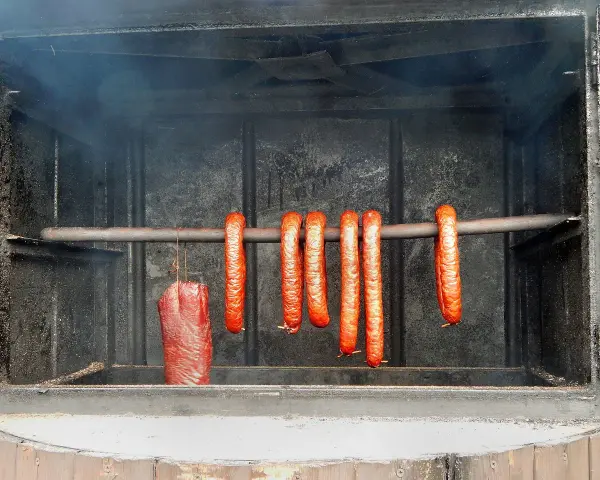 Kiełbasa wędzi się w dymie, tworząc apetyczny kolor. Idealna temperatura wędzenia kiełbasy to klucz do sukcesu.