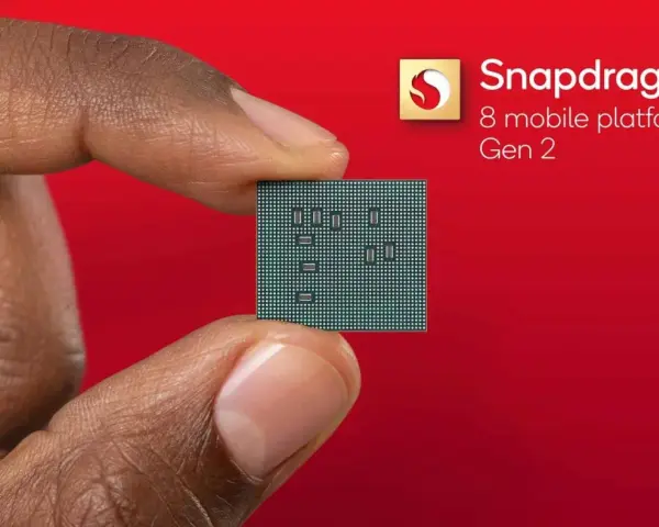 Palec i kciuk trzymają niewielki procesor. Obok widnieje logo Snapdragon 8 mobile platform Gen 2.
