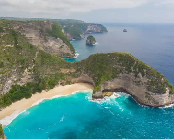 Widok z lotu ptaka na klify, piaszczystą plażę i turkusowe morze na Bali.