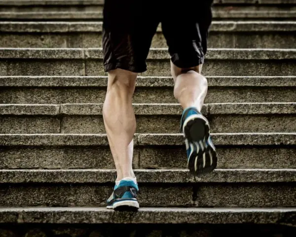 Un homme monte des escaliers, sollicitant ses mollets pour un excellent exercice.