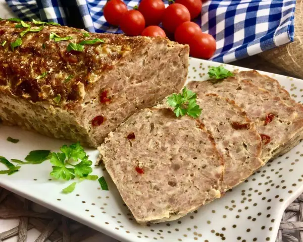 Klasyczna pieczeń rzymska, soczysta i aromatyczna, pokrojona na plastry, ozdobiona natką pietruszki.