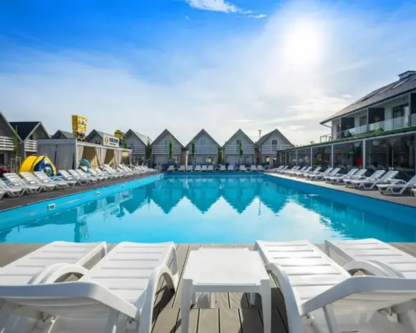 Słoneczny basen z leżakami w holiday park & resort Grzybowo. Opinie o tym miejscu są świetne!