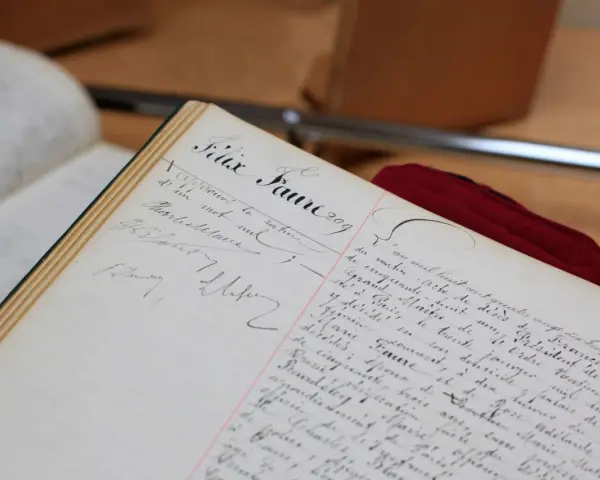 Comment consulter les registres d'état civil sur internet : un livre ancien manuscrit, peut-être un registre d'état civil, avec des écritures calligraphiées.