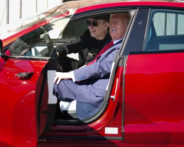 Elon Musk i Donald Trump siedzą w czerwonym samochodzie Tesla.