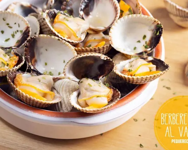 Deliciosos berberechos al vapor, recién cocidos y espolvoreados con perejil fresco. Un bocado del mar.