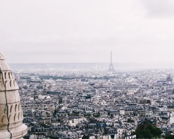 Vista panorámica de París con la Torre Eiffel al fondo. La arquitectura de la ciudad evoca un sentimiento de "enchanté significado".