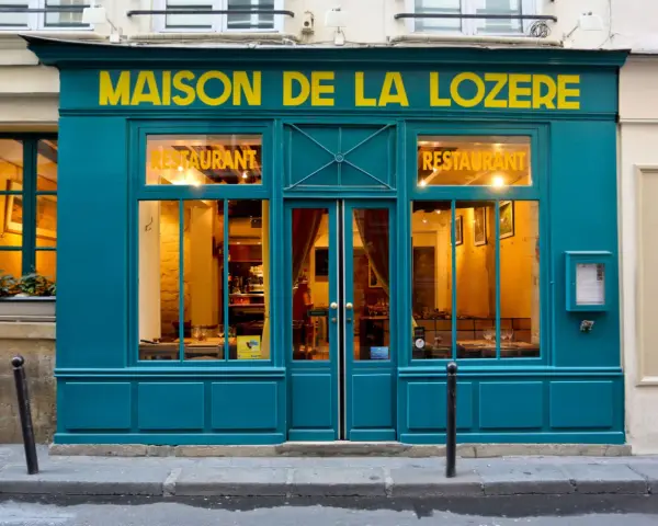 Maison de la Lozère, un ristorante accogliente dove mangiare a Parigi. L'insegna gialla risalta sulla facciata turchese.