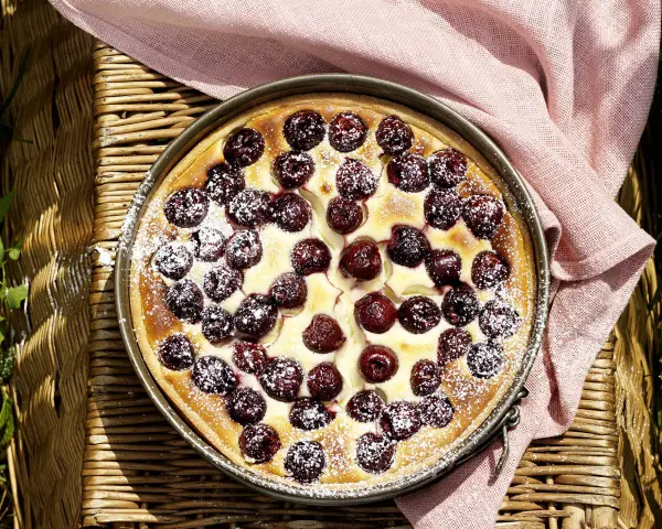 Ein köstlicher Kirschkuchen, bestäubt mit Puderzucker. Perfekt für sommerliche sauerkirschen rezepte.