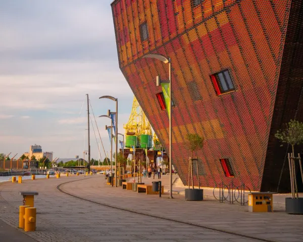 Nowoczesna architektura i portowe klimaty – to właśnie co można zwiedzić w Szczecinie. Widok na nabrzeże z charakterystycznym budynkiem.