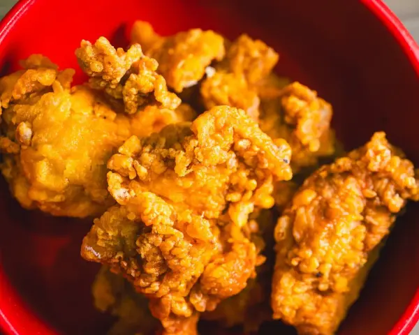 Chrupiący kurczak karaage w czerwonej misce. Idealna przekąska na imprezę.