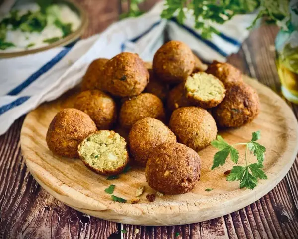 Frisch zubereitete Falafel auf einem Holzbrett, perfekt zum falafel selber machen. Ein Genuss für jeden Liebhaber der orientalischen Küche.