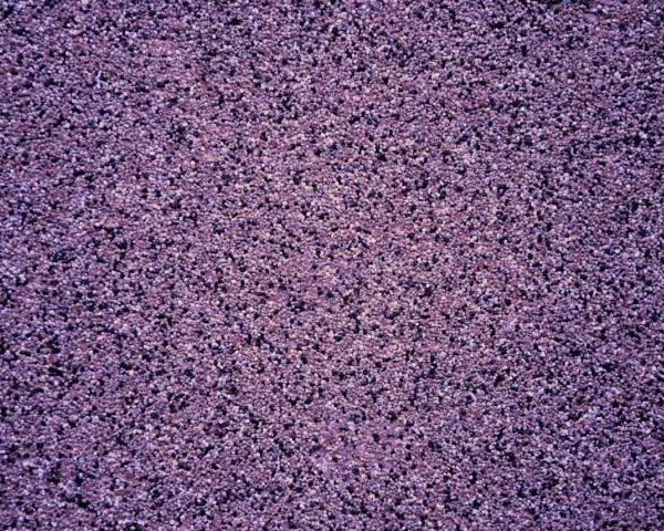 Fioletowy tynk mozaikowy o drobnej granulacji. Wydajność 15 kg na ok. 3-4 m² powierzchni, zależnie od grubości warstwy.