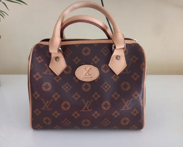 Brązowa louis vuitton torebka kuferek z monogramem. Elegancka, z jasnymi rączkami i detalami.