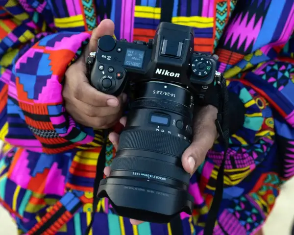 Osoba trzyma aparat Nikon Z6 z obiektywem NIKKOR Z 14-24mm f/2.8 S. Wśród wielu marek aparatów fotograficznych, Nikon wyróżnia się jakością.