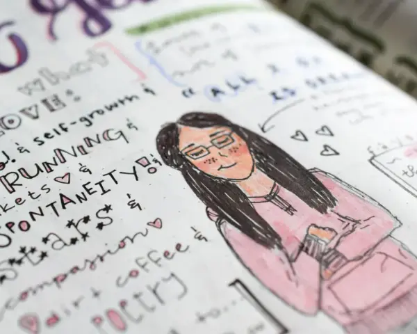 Rysunek w bullet journalu: uśmiechnięta dziewczyna w okularach i różowej bluzie, otoczona listą rzeczy, które kocha, jak bieganie i kawa.