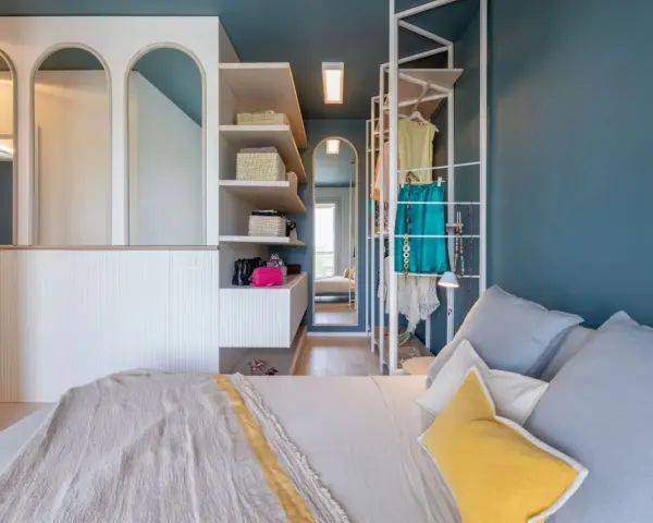 Progetto camera da letto con cabina armadio: letto, scaffali con cesti, abiti appesi e specchi ad arco.