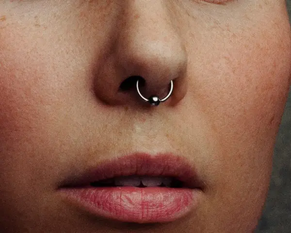 Zbliżenie na twarz z kolczykiem w nosie (septum). Czy septum boli? To pytanie zadaje sobie wiele osób przed piercingiem.