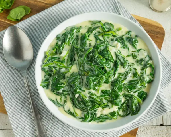 Un plato cremoso de espinacas con bechamel, listo para disfrutar.